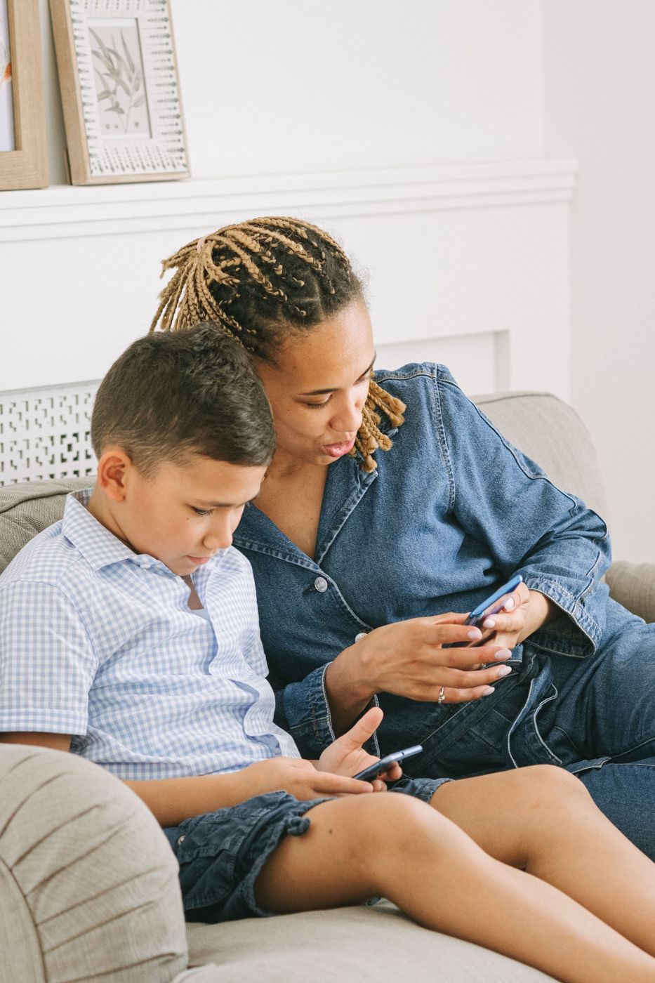 A mother and son on the sofa looking at a phone together